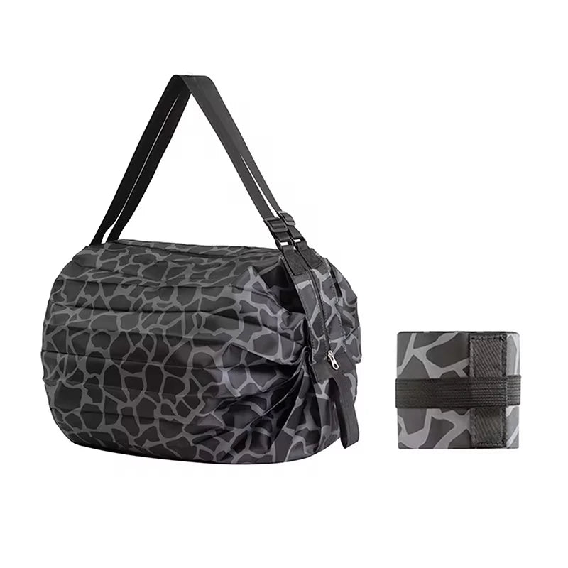 Black Oxford shopping bag with giraffe print and black straps, shown next to its folded version secured with a matching elastic band
